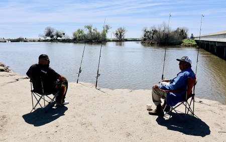 Fishermen Mario Chavez Jr. and his father, Mario Chavez Sr. (right) fish for catfish on the Kings River south of Stratford.